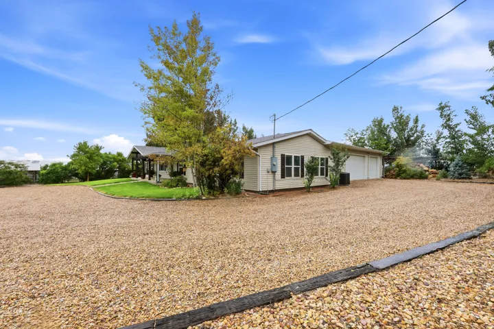 Expansive gravel driveway leading to a two-car garage