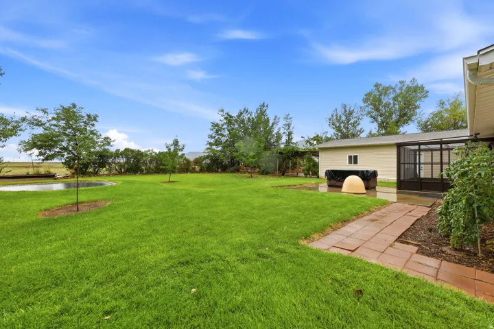 Expansive green lawn with a water feature, accompanied by a terracotta paver pathway
