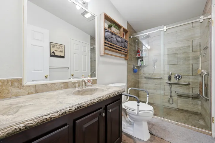 Vanity with an integrated sink and decorative edge detailing, a tiled backsplash, and a framed mirror