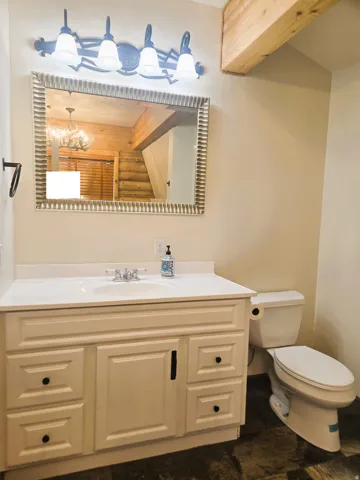 White vanity with black hardware, integrated sink, and white countertop