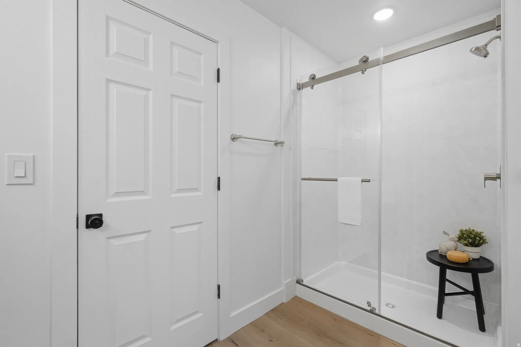 Primary bath with modern shower enclosure with a sliding glass door, white tile surround, and a chrome shower head