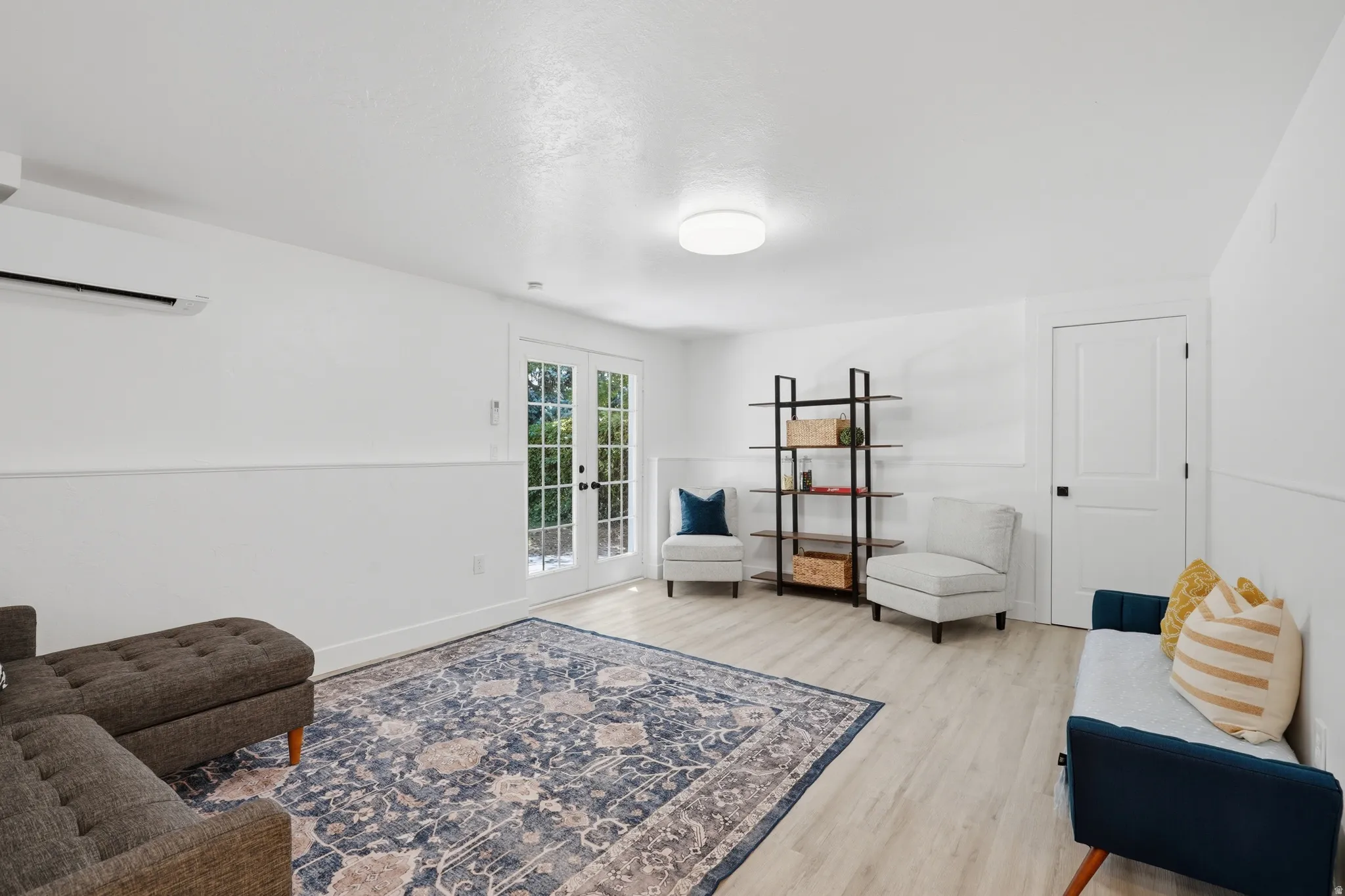 ADU living room with light laminate flooring, exterior entrance.