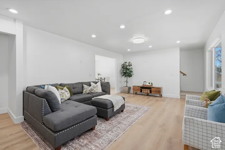 Bright living area featuring wood-finish LVP flooring, recessed lighting, and large windows
