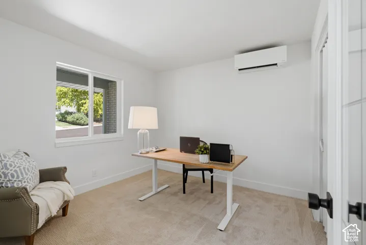 Bedroom 1 (staged as an office) White walls, carpeted flooring, window with mountain views, and a wall-mounted mini-split system