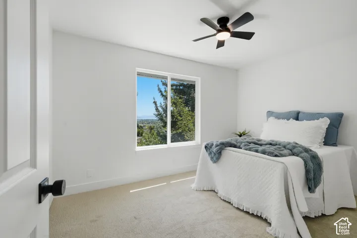 Bright bedroom #2 with incredible views, white walls, and a ceiling fan with integrated lighting