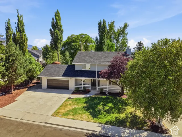 Two-story residence with a dark shingle roof, attached two-car garage, and a concrete driveway