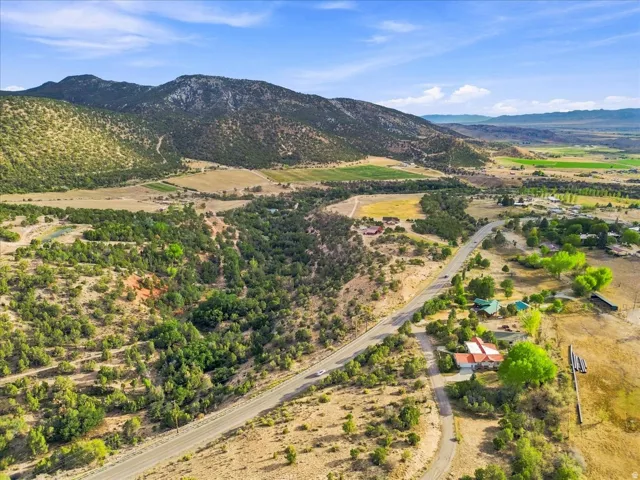 Expansive mountain landscape with diverse terrain, including wooded areas and open fields
