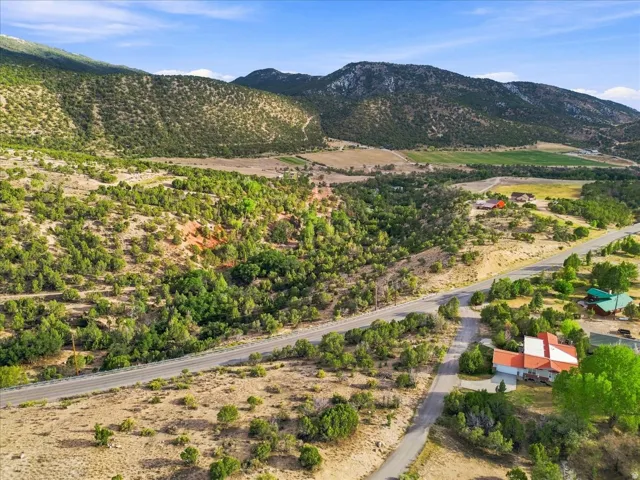 Expansive mountainous terrain with varied vegetation and visible roadway