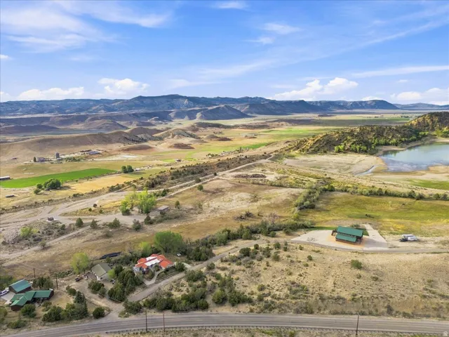 Expansive land with multiple structures, natural water features, and distant mountain ranges
