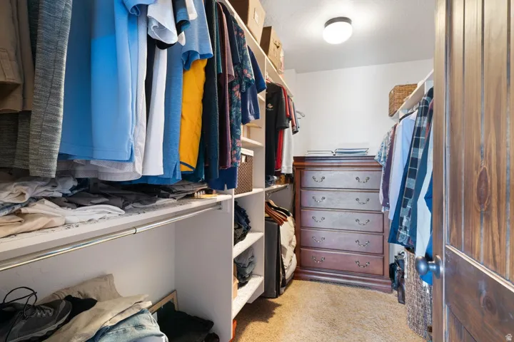 Built-in shelving, hanging rods, recessed lighting, and a paneled wooden door