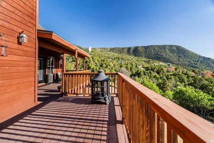 Expansive wooden deck featuring sturdy railings and a covered porch area