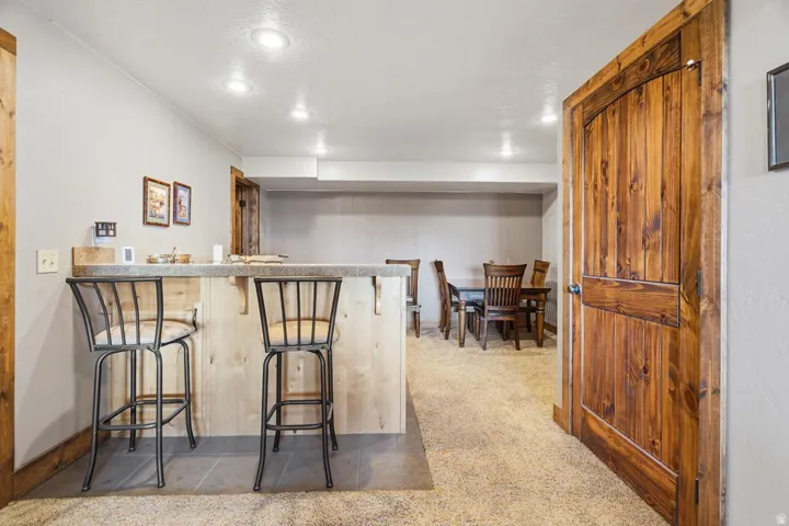 Recreational space featuring a built-in bar with a light wood-finish base and solid surface countertop
