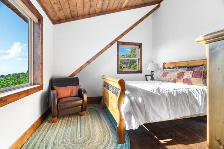 Vaulted wood-paneled ceiling, white walls, and wood-finish flooring