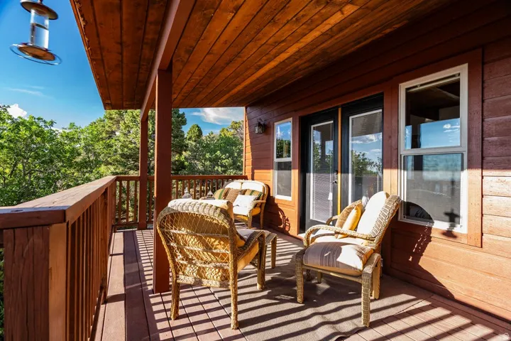 Expansive outdoor deck with wood-finish ceiling, wood-slat railing, and a durable composite deck surface