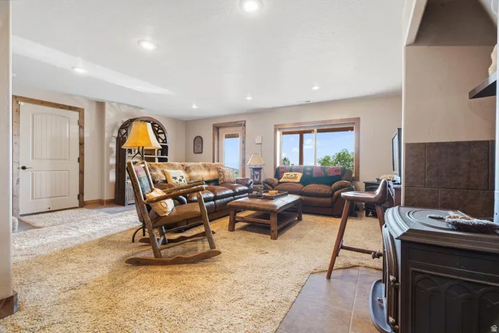 Recessed lighting, wood-trimmed windows, wood-trimmed door, arched alcove, and a built-in wood-burning stove