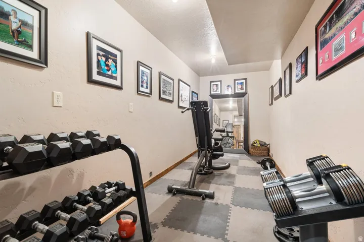Dedicated exercise space featuring checkered interlocking floor mats and recessed lighting
