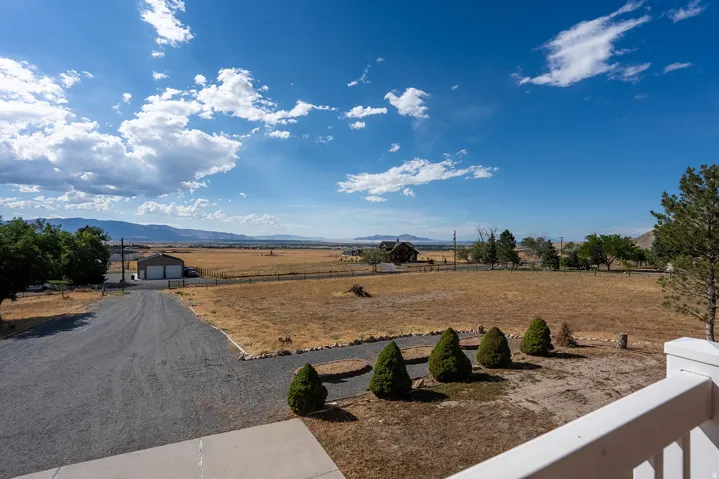 Expansive open fields with distant mountain ranges and a visible lake