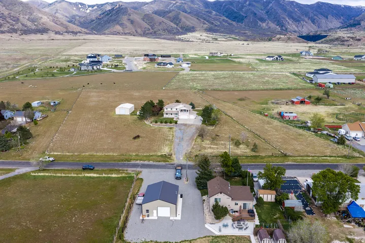 Expansive property featuring a detached garage structure, a multi-level dwelling, and a large paved area