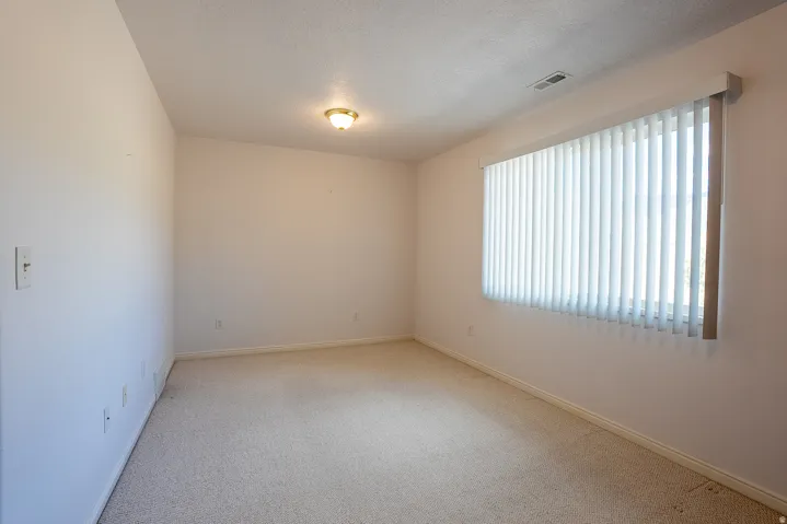 Carpeted flooring, vertical blinds, and a built-in ceiling light fixture