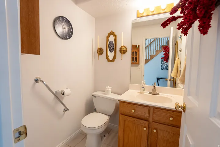 Vanity with wood-finish cabinetry, integrated sink, and wall-mounted mirror