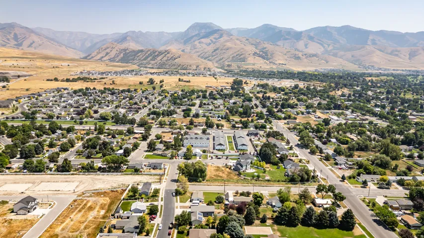 Expansive residential development with mountain backdrops, established trees, and open land parcels