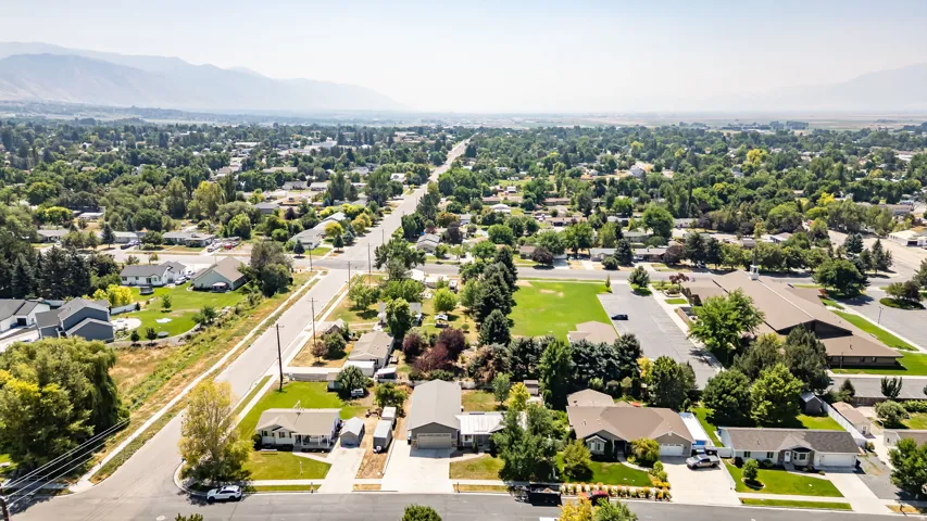 Residential neighborhood with mature trees, established properties, and distant mountains