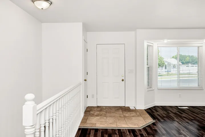 Recessed lighting illuminates the living space with wood-finish flooring