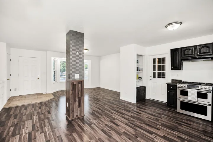 Wood-finish flooring throughout, bay windows, white paneled doors, and stainless steel range with a double oven