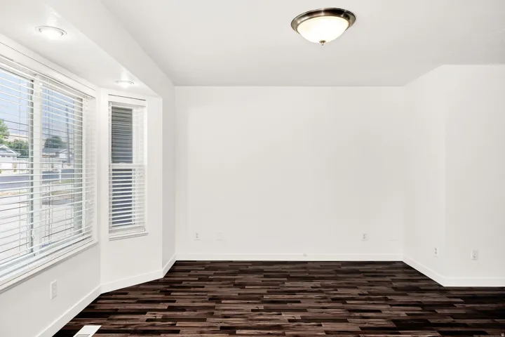 Bay window with white blinds, recessed lighting, wood-finish flooring, and a flush mount ceiling light fixture