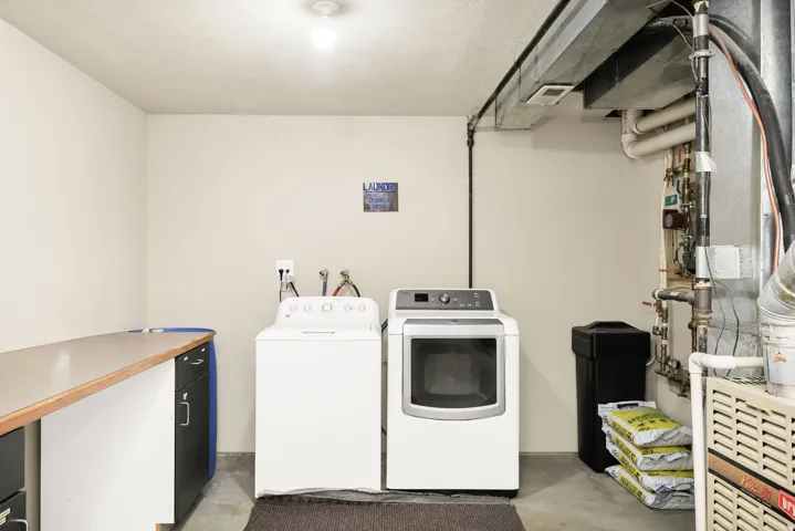 Laundry area featuring a utility sink, a countertop workspace, and concrete flooring
