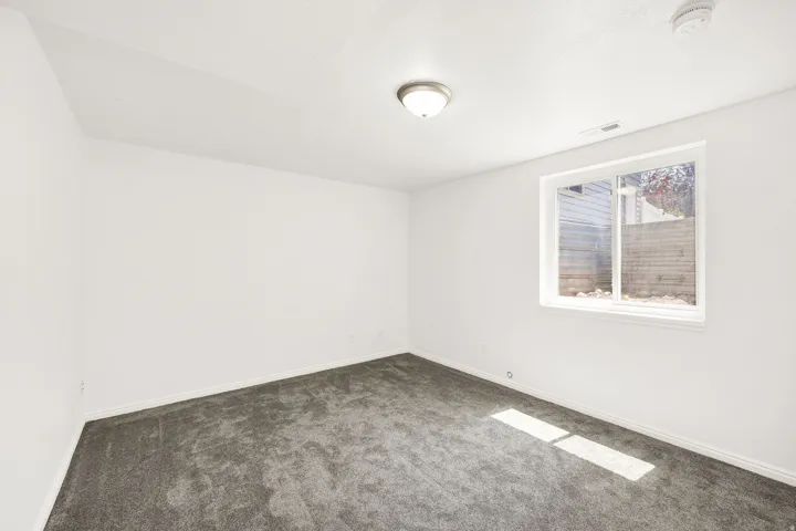 Recessed window with white trim, gray carpet, and white painted walls