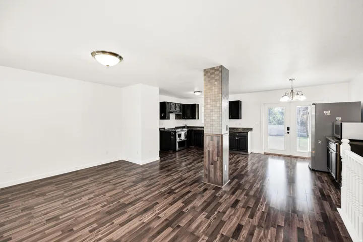 Wood-finish flooring throughout, white walls, and a tiled structural column