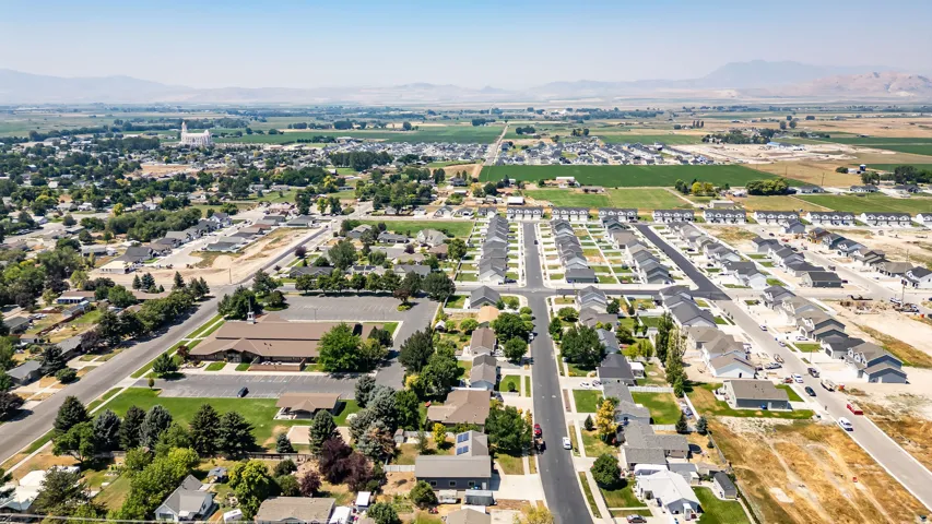 Aerial perspective showcasing a residential development with established green spaces and a mountain backdrop