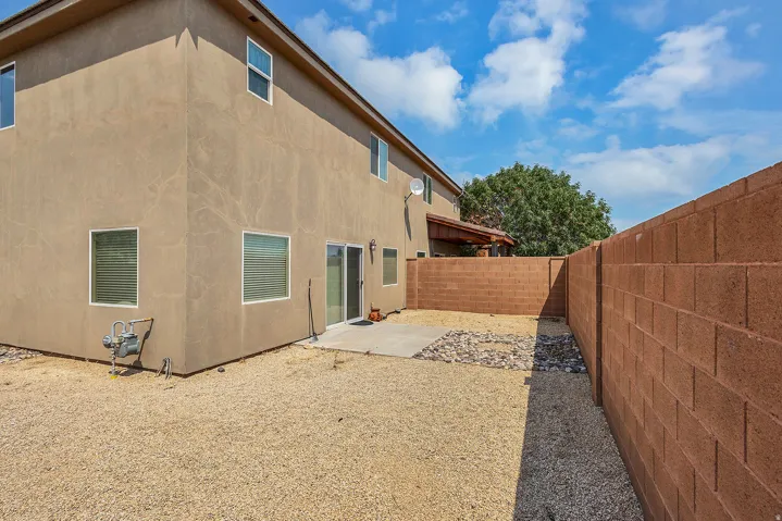 Stucco exterior with multiple windows and a sliding glass door