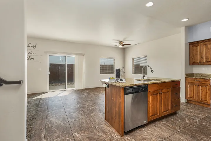 Kitchen island with a stainless steel dishwasher, undermount sink, and granite countertop