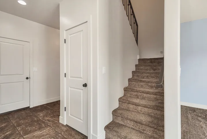 Interior staircase with dark metal balusters and carpeted treads
