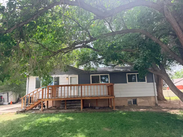 Exterior featuring a wooden deck, multiple windows, and partial siding