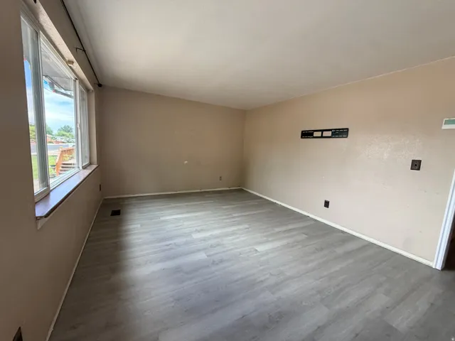 Neutral wall finishes with a large window, providing ample natural light
