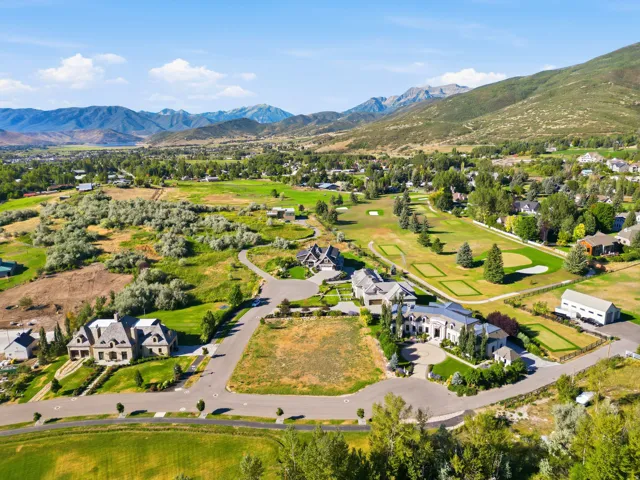 Expansive property featuring a large level lot, surrounding mountain range, and adjacent golf course