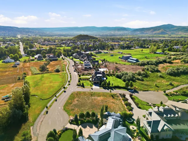 Expansive landscape featuring developed properties, paved roads, and distant mountains