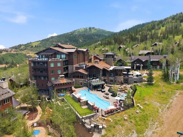 Multi-level residential complex featuring a large outdoor swimming pool and multiple terraces