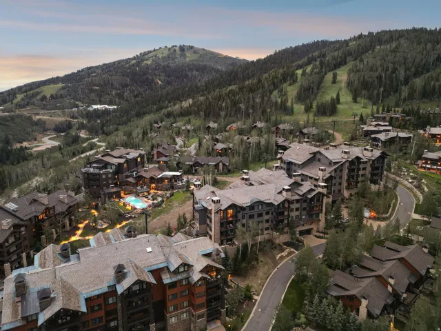 Mountain resort community featuring multiple residential buildings, paved roadways, and extensive tree coverage