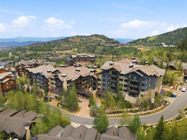 Multi-story buildings with stone and wood siding, multiple balconies, and dormer windows