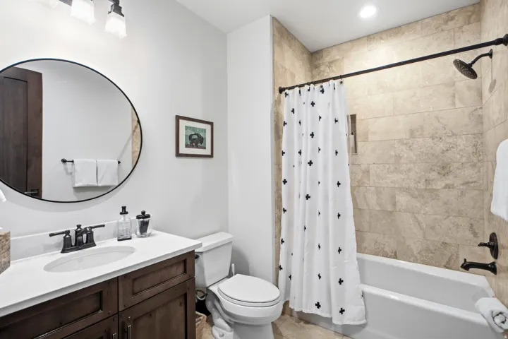 Bathroom featuring a wood-finish vanity with a white countertop and undermount sink