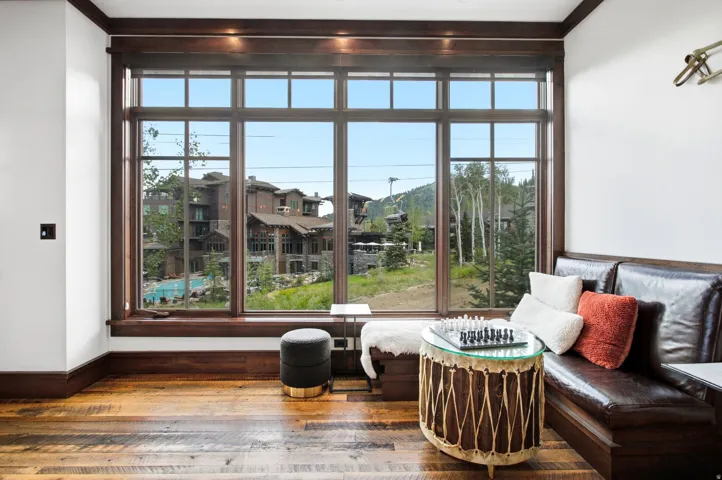 Hardwood flooring, expansive multi-pane window, dark wood trim, built-in leather bench seating, recessed lighting