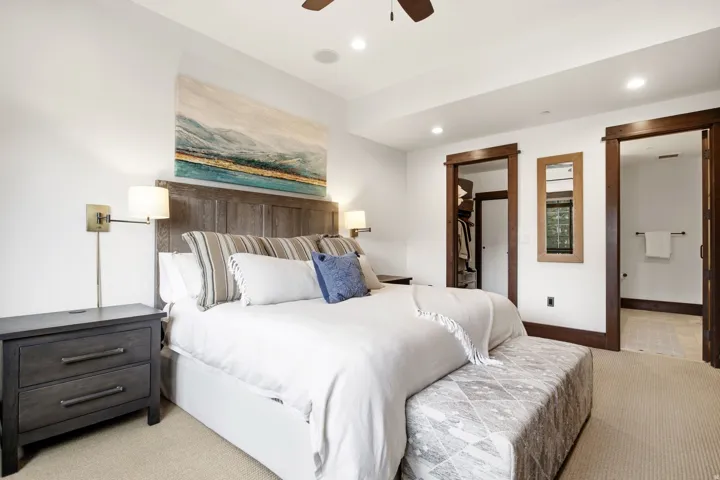Recessed lighting, wood-finish ceiling fan, wood-finish door frames, wall-mounted sconces, and built-in closet