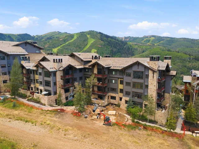Mountain-modern multi-story building featuring stone and wood-look siding