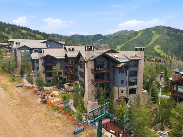 Stone and wood-sided multistory building with multiple balconies and prominent chimney structures