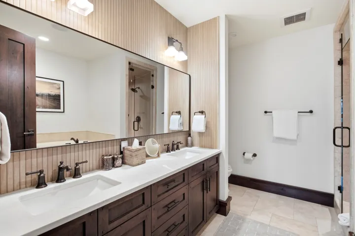 Dual vanity with integrated sinks and dark wood-finish cabinetry
