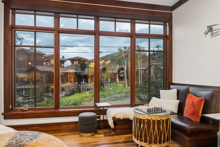 Expansive window wall with wood-finish framing, wood-finish flooring, and a built-in upholstered bench with storage